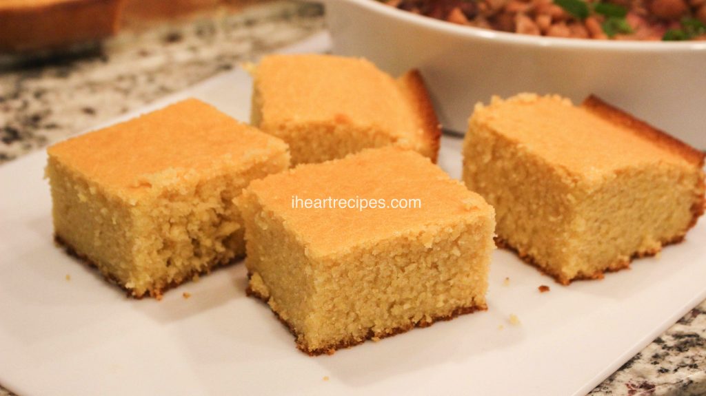 Four square slices of homemade sweet Southern cornbread are served on a platter. 
