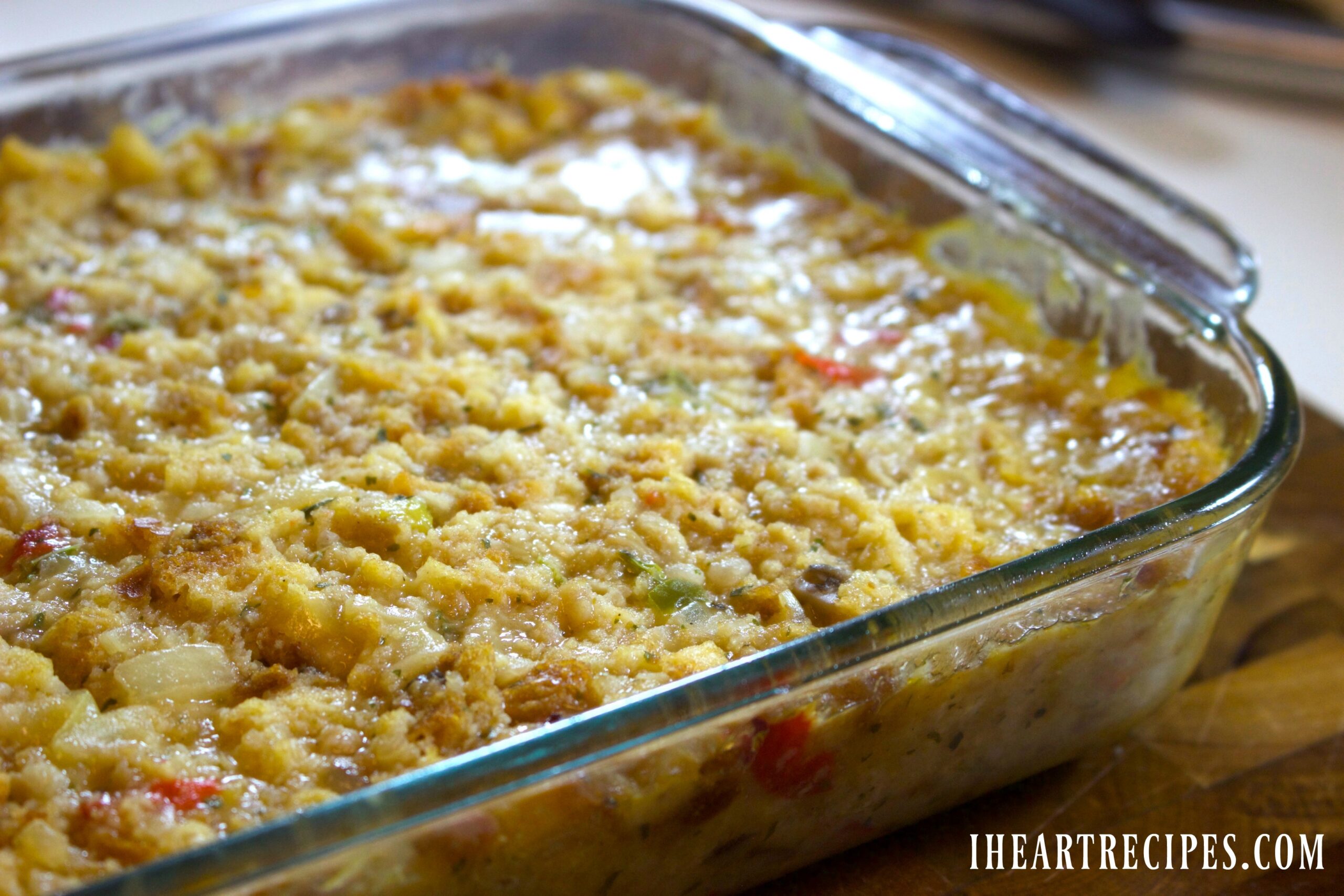 A side angle image of a glass casserole dish filled with a homemade Southern cornbread dressing.