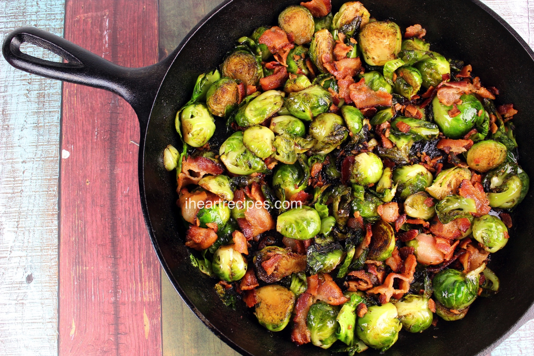 An overhead image of a cast iron skillet filled with roasted brussels sprouts and bacon -- the perfect Thanksgiving side dish.