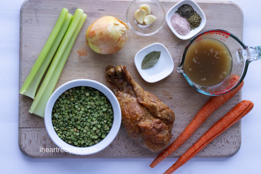 Individual ingredients for soup separated on a wooden cutting board. 