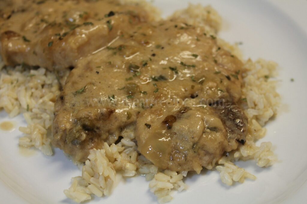 Tender smothered pork chops, covered with a homemade onion gravy and served atop a bed of white rice.