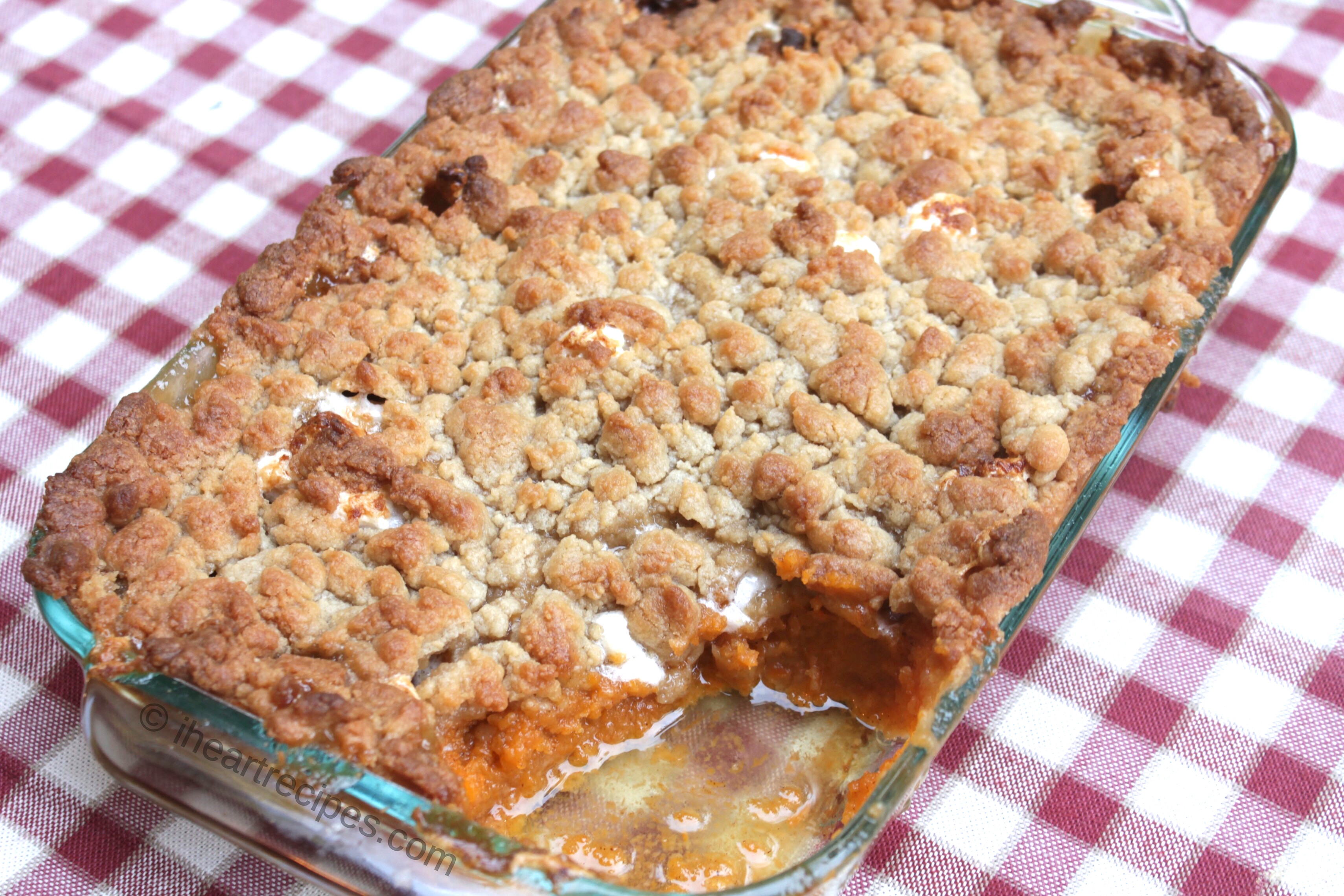 A Southern style sweet potato casserole topped with a golden-brown crumble topping and a layer of marshmallows atop the sweet, soft spiced sweet potatoes.